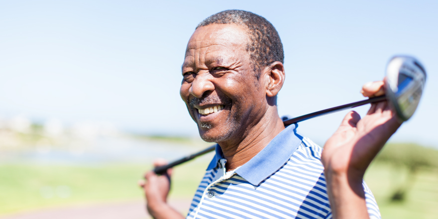 Man holding golf club around the back of his neck at Gulf Shores golf course