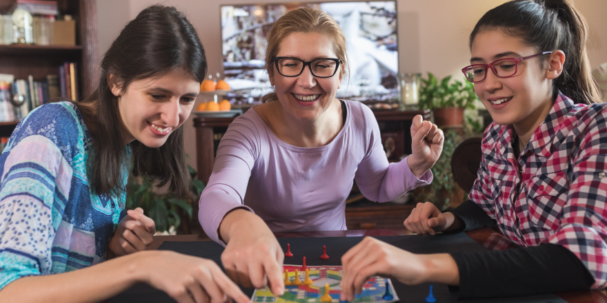 Family sitting at table playing a board game