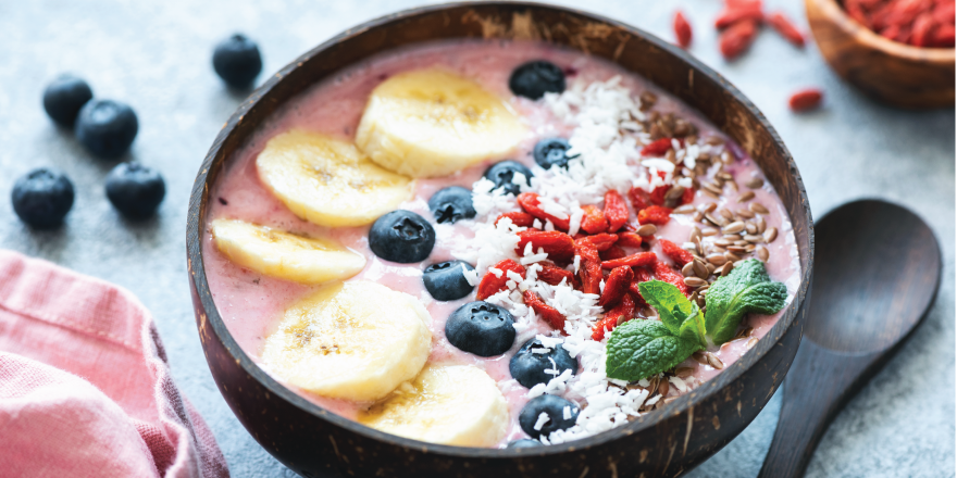 Acai bowl with bananas, blueberries, goji berries and mint