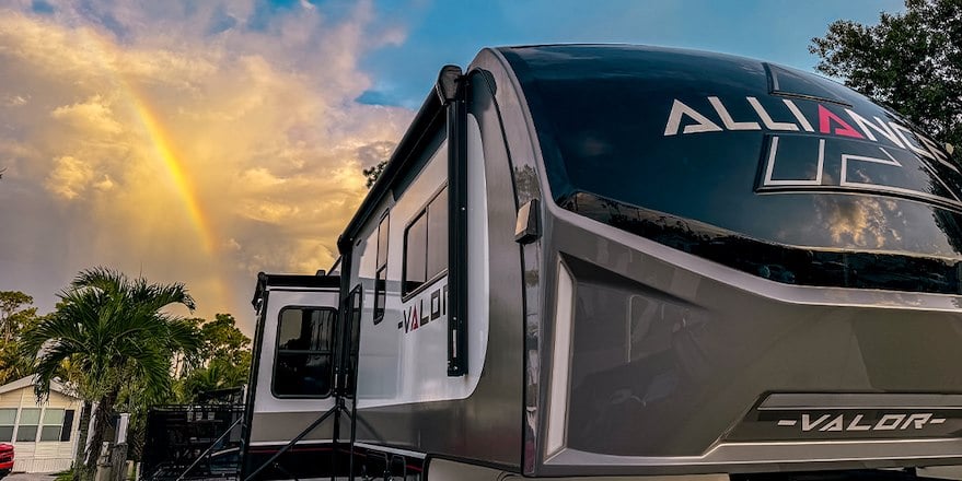 Image of an RV with a rainbow in the sky