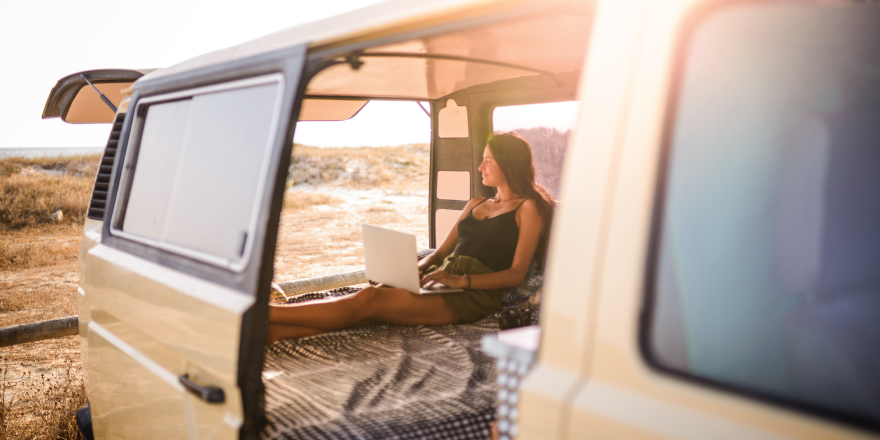 Woman working on computer from back of RV